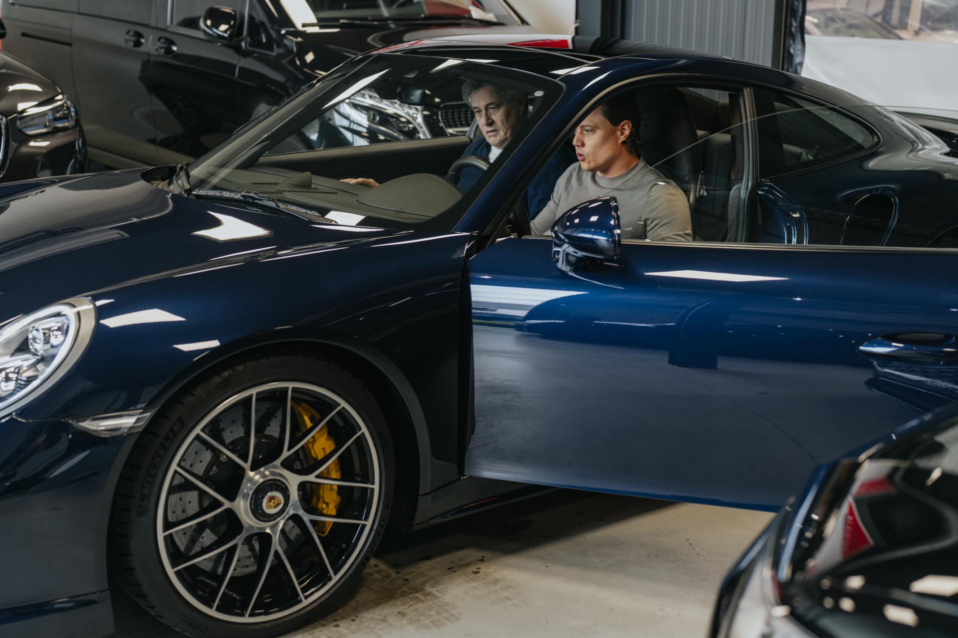 Klant in een Porsche 911 in de showroom van Trex Cars