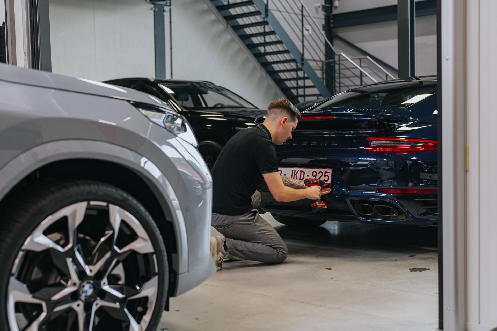 Kentekenplaat wordt bevestigd met gereedschap op auto
