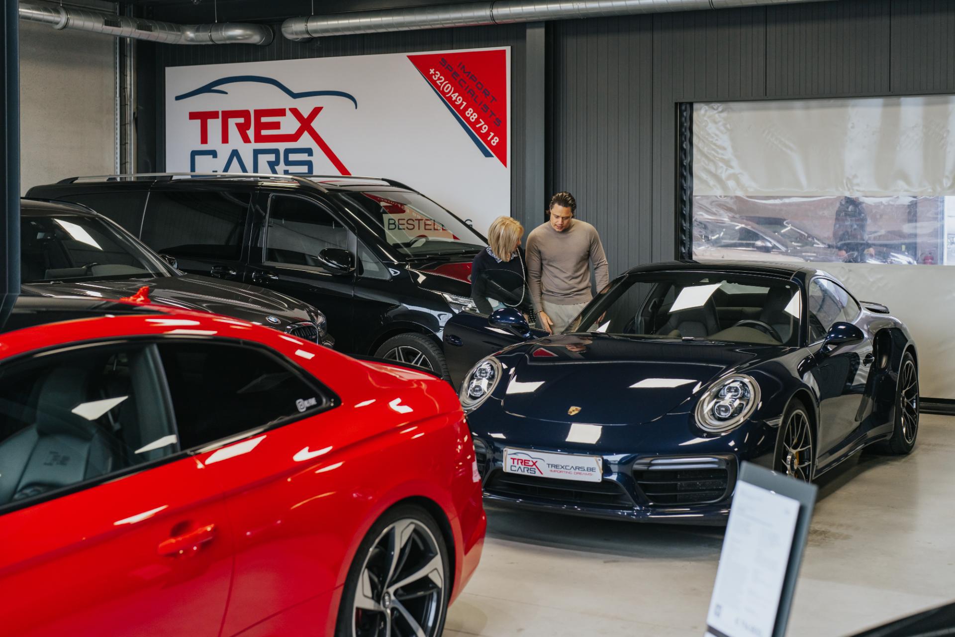 Klant bekijkt het interieur van een Porsche in de showroom van Trex Cars