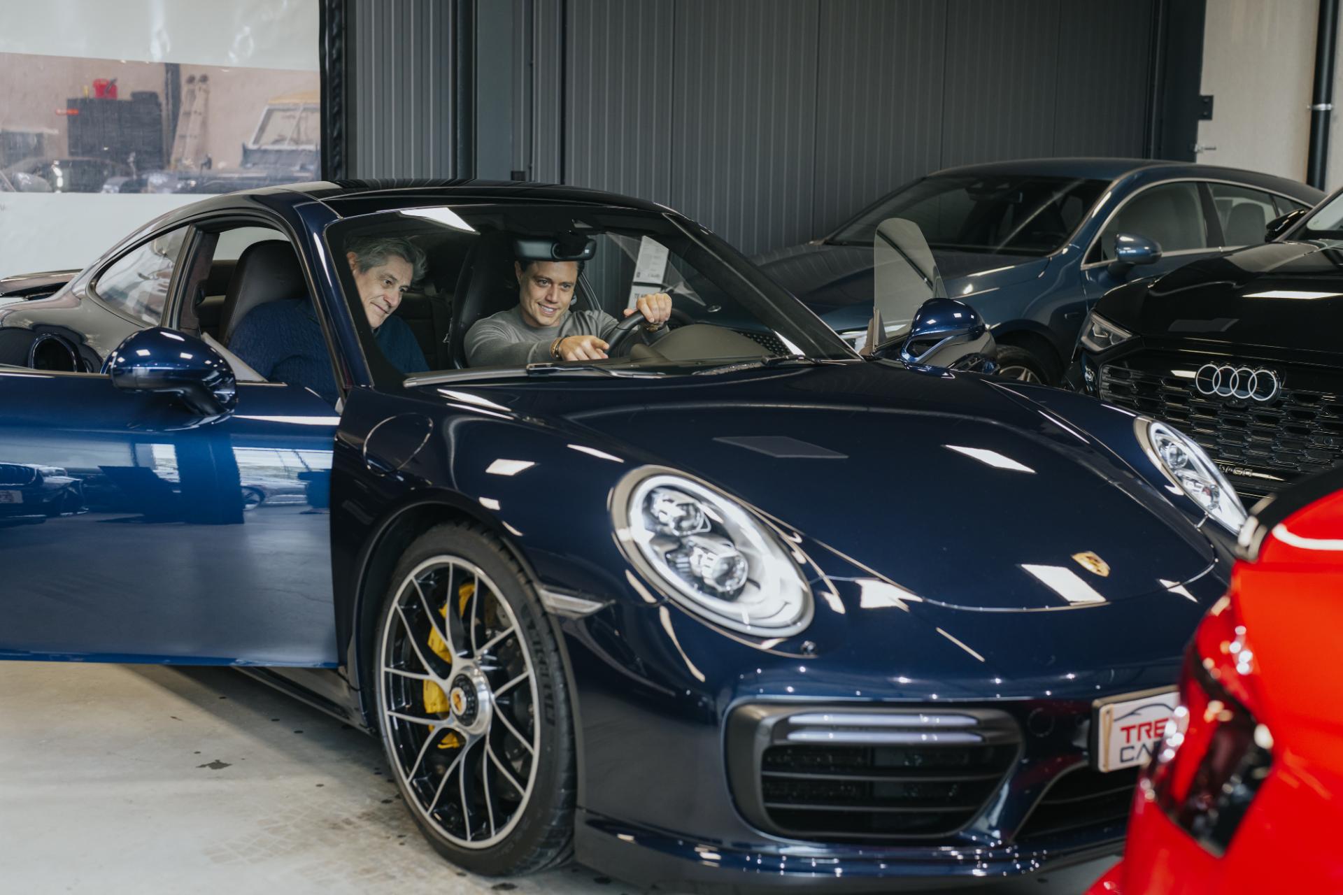 Klant test sportwagen in showroom met begeleiding